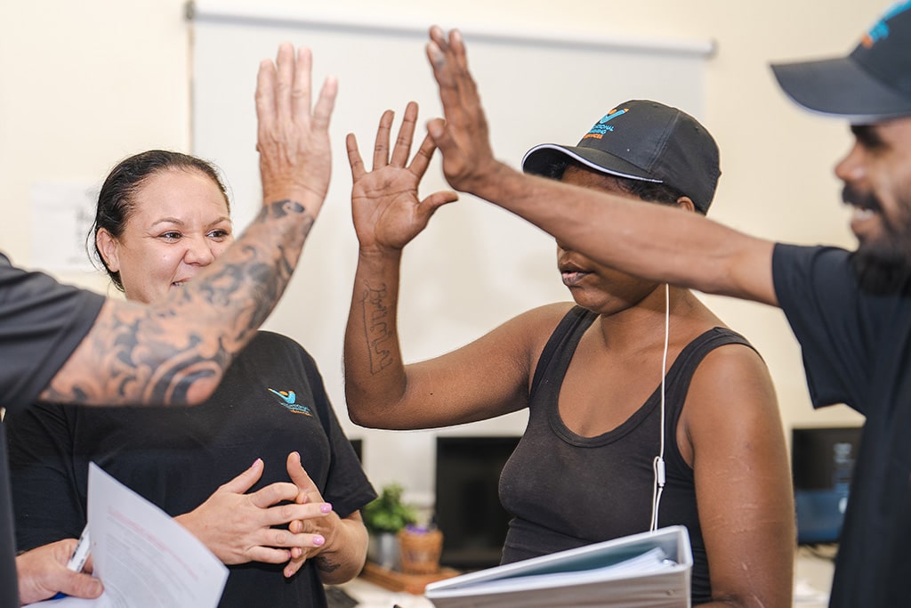 Students at VTS Broome giving each other a high five.