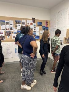 Students, trainers and sponsors including Kimberley MLA Divina D'Anna review posters and notes on a classroom wall.